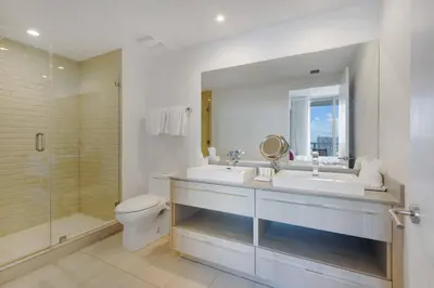 a bathroom with two sinks and a shower and a toilet at 23rd-Floor Views • Pool Gym Beach Service in Hollywood