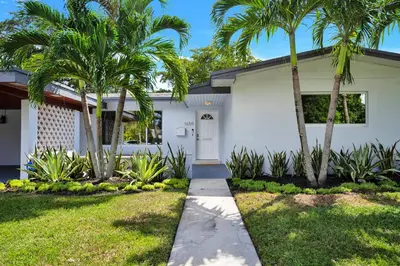 a white house with palm trees in front of it at Outdoor Paradise in Fort Lauderdale