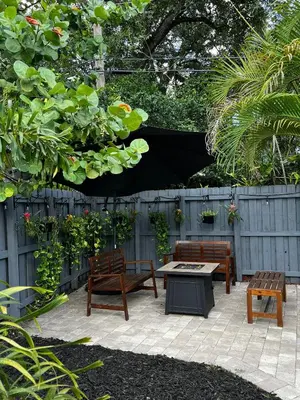 a patio with two benches and a table and a fence at Outdoor Paradise in Fort Lauderdale