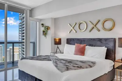 a bedroom with a large bed with a xo sign on the wall at Icon Luxury 34th Floor Amazing Oceanview, Brickell in Miami