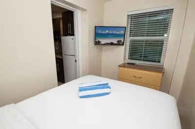 a small room with a white bed and a window at Caribbean Resort by the Ocean in Hollywood