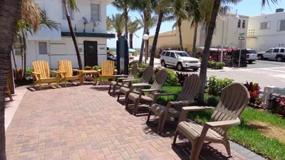 a row of chairs and tables on a sidewalk at Caribbean Resort by the Ocean in Hollywood
