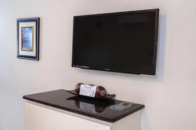a flat screen tv hanging on a wall with a table at Caribbean Resort by the Ocean in Hollywood