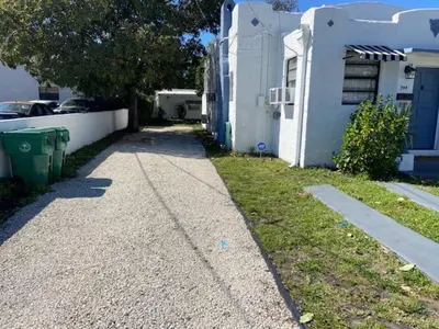 a sidewalk in front of a white house at Cozy rooms in cute house, close to Miami airport - Free parking in Miami