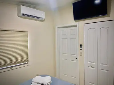 a room with a window and a air conditioner on the wall at Cozy rooms in cute house, close to Miami airport - Free parking in Miami