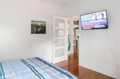 a bedroom with a bed and a flat screen tv at Blue Ocean Vacation Home 1 in Fort Lauderdale