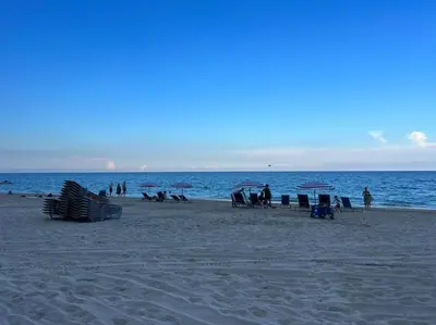 a group of people on a beach near the ocean at Relaxing BeachWalk Getaway, Studio for 4 Guests in Hallandale Beach