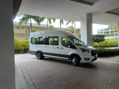 a small white van parked under a building at Relaxing BeachWalk Getaway, Studio for 4 Guests in Hallandale Beach