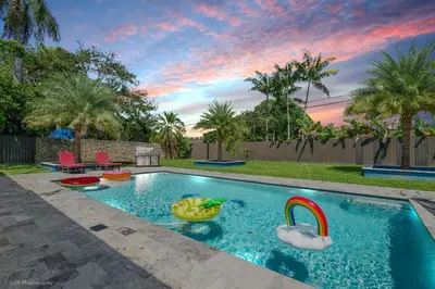 a swimming pool with a toy duck in a backyard at The Palms -Mini Golf , Foosball Table, Heated Pool ,Baby items ,BBQ in Miami