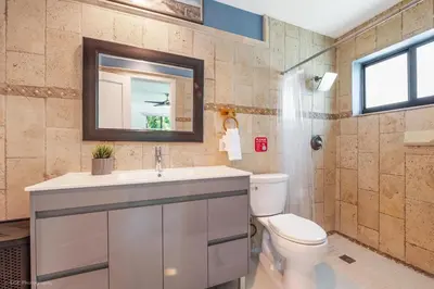 a bathroom with a toilet and a sink and a mirror at The Palms -Mini Golf , Foosball Table, Heated Pool ,Baby items ,BBQ in Miami