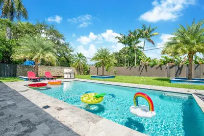 a swimming pool with a toy duck in a backyard at The Palms -Mini Golf , Foosball Table, Heated Pool ,Baby items ,BBQ in Miami