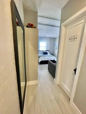 a room with a toilet sign on the wall and a bedroom at Orange You Glad you came in Miami