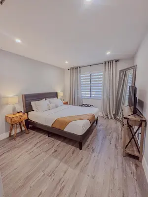 a bedroom with a bed and a television in it at Zoka House 5 mints from Brickell in Miami