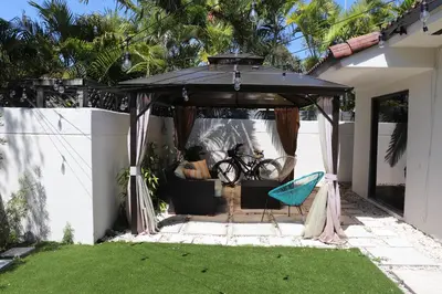 a patio with a black umbrella and a chair at Zoka House 5 mints from Brickell in Miami