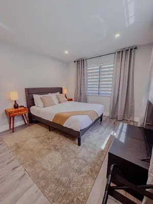 a bedroom with a bed and a table and a couch at Zoka House 5 mints from Brickell in Miami
