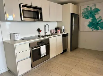 a kitchen with a stove and a microwave at Sunset Views & Style, Chic Beachfront in Miami -A in Hallandale Beach