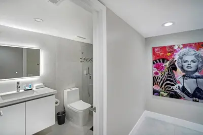 a bathroom with a toilet and a painting on the wall at Higher Love! Water Views and Cool Vibes in Miami