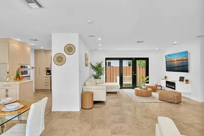 a living room with white furniture and a kitchen at Tropical Oasis With heated pool 10 mins airport & 5 mins Beach in Hollywood