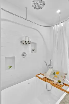 a bathroom with a bath tub and a tray with a book at Tropical Oasis With heated pool 10 mins airport & 5 mins Beach in Hollywood