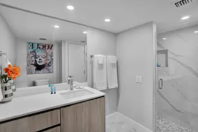 a white bathroom with a sink and a shower at Euphoria - Miami Skyline & Water Views in Miami