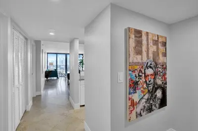 a painting hanging on a wall in a hallway at Euphoria - Miami Skyline & Water Views in Miami
