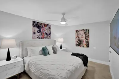 a white bedroom with a bed and two pictures on the wall at Euphoria - Miami Skyline & Water Views in Miami