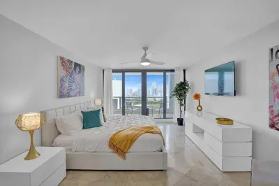 a white bedroom with a bed and a window at Euphoria - Miami Skyline & Water Views in Miami