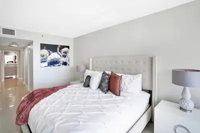 a white bedroom with a large white bed with pillows at Stay in Love! Miami Skyline Views, Renovated in Miami