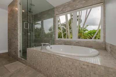 a large bathroom with a tub and a window at Miami Dream Home/ Pool/Jacuzzi/ Fire Pit in Miami