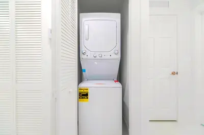 a white refrigerator in a room next to a door at Stunning 3-Bedroom Duplex with Free Parking in Miami