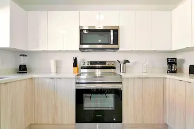 a kitchen with white cabinets and a microwave at Stunning 3-Bedroom Duplex with Free Parking in Miami
