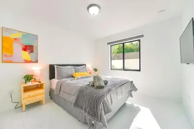 a white bedroom with a bed and a window at Stunning 3-Bedroom Duplex with Free Parking in Miami
