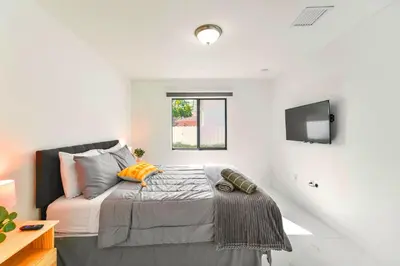 a bedroom with a bed and a tv on the wall at Stunning 3-Bedroom Duplex with Free Parking in Miami