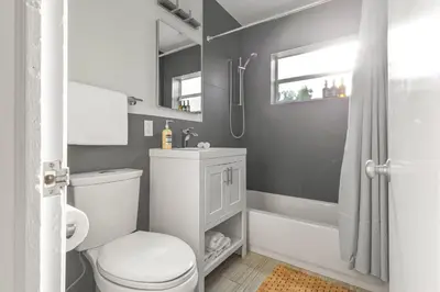 a bathroom with a white toilet and a shower at Casa Limon - Private Heated Pool Prime Location & Parking in Fort Lauderdale