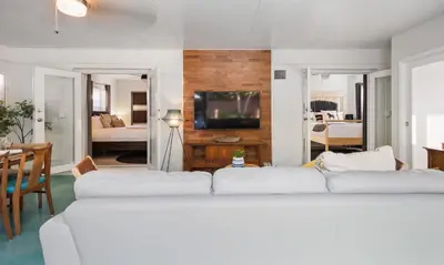 a living room with two white couches and a bedroom at Casa Limon - Private Heated Pool Prime Location & Parking in Fort Lauderdale