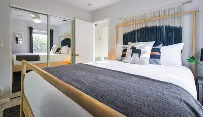 a bedroom with a large bed and a mirror at Casa Limon - Private Heated Pool Prime Location & Parking in Fort Lauderdale