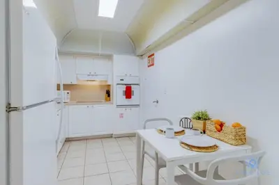 a kitchen with white cabinets and a white table at Paradise Retreat, Near Beach, Casino, and More in Hollywood