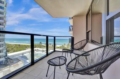 a balcony with two chairs and a view of the ocean at Breathtaking resort condo w beach service Unit 908 in Miami Beach