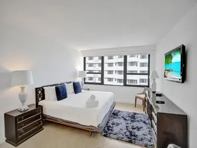 a bedroom with a large bed and a window at Modern Ocean View Condo Beach Service Unit 1206 in Miami Beach