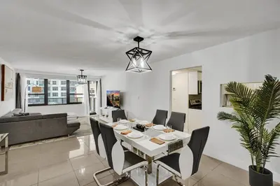 a dining room and living room with a table and chairs at Ocean View condo w beach service 411 in Miami Beach