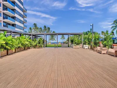 a large patio with chairs and trees and a building at Ocean View condo w beach service 411 in Miami Beach
