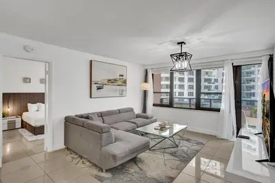 a living room with a couch and a bed at Ocean View condo w beach service 411 in Miami Beach