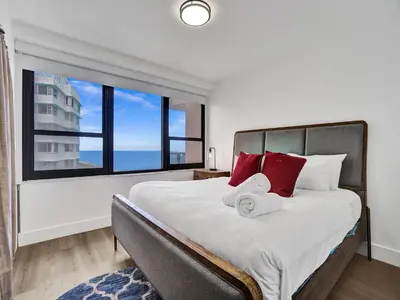 a bedroom with a large bed with red pillows at Ocean View Condo Beach Service 1504 in Miami Beach