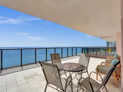a balcony with a table and chairs and the ocean at Huge Terrace Oceanfront Condo Beach Service 1502 in Miami Beach