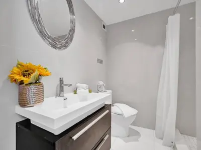 a bathroom with a sink and a mirror and a toilet at Fantastic condo w beach service 615 in Miami Beach