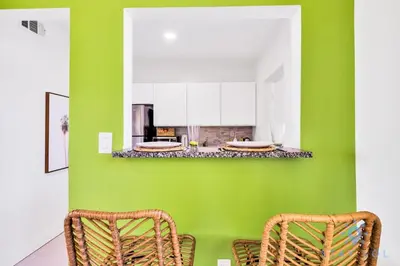 a green kitchen with two chairs and a counter at Free Parking - Bay View - Pool -Step To Beach in Hollywood