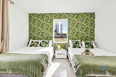 two beds in a room with a green wall at Free Parking - Bay View - Pool -Step To Beach in Hollywood