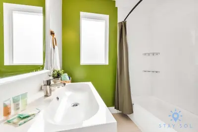 a bathroom with a white sink and a green wall at Free Parking - Bay View - Pool -Step To Beach in Hollywood