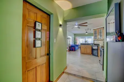a kitchen with green walls and a wooden door at Fun Getaway: Hot Tub, Tiki Bar, Arcade Room in Hollywood