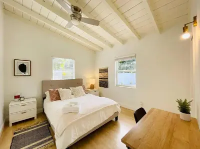 a bedroom with a white bed and a wooden table at Tropical Oasis House Private Pool Family Yard in Fort Lauderdale